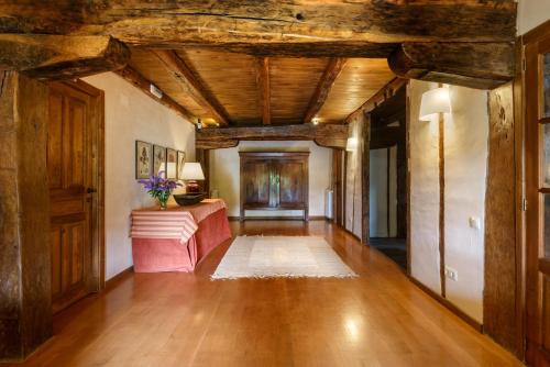 a living room with wooden ceilings and a wooden floor at Hotel Akerreta in Akerreta