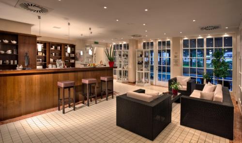 a lobby with a bar and some chairs and tables at Hotel Vier Jahreszeiten Binz in Binz