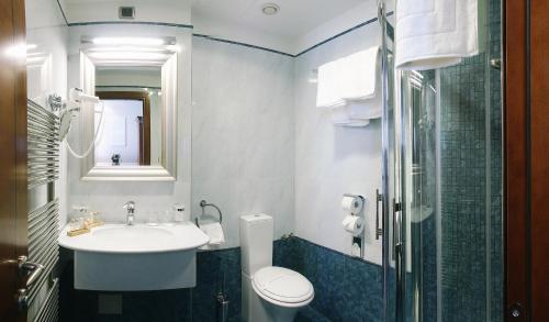 a bathroom with a toilet, sink, and shower at Best Western Premier Hotel Astoria in Zagreb