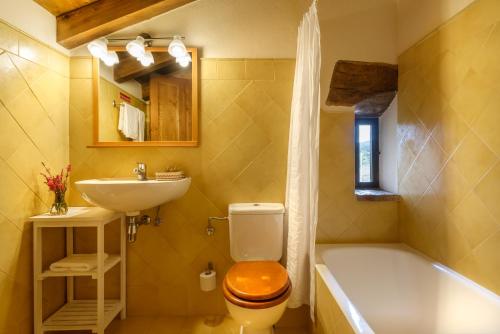 a bathroom with a toilet and a sink and a tub at Hotel Akerreta in Akerreta