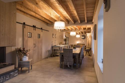 B&B De Windheer في Sint-Martens-Lennik: مطبخ وغرفة طعام مع طاولة وكراسي