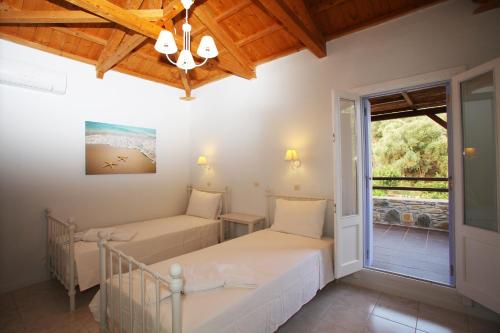 1 dormitorio con 2 camas y ventana en Ktima Kehrioti en Panormos Skopelos