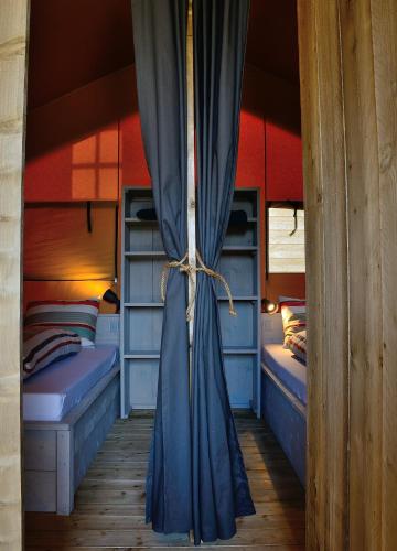 a room with two bunk beds and a curtain at Safaritent in Oostvoorne