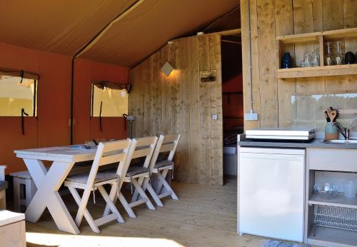 cocina con mesa y sillas en una habitación en Safaritent, en Oostvoorne