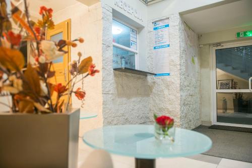 Hostel CENTRUM في رادوم: طاولة في غرفة مع إناء من الزهور
