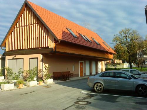 une voiture garée devant une maison avec un toit orange dans l'établissement Guest accomodation Klancar, à Ig
