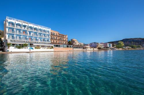 un grande edificio sull'acqua vicino a una città di Hotel Tolo a Tolo