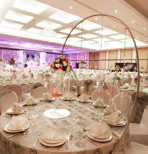 a banquet hall with a long table with white chairs at Ramada Hotel & Suites by Wyndham Ajman in Ajman 
