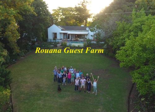 a group of people standing in the grass in front of a house at Rouana Guest Farm in Stellenbosch