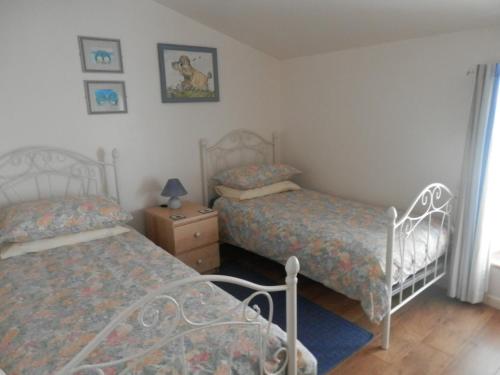 - une chambre avec 2 lits et une table de chevet dans l'établissement Maison de Laura, à Salsigne