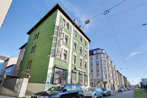 a green and white building on a city street at Bavaria Hotel Münchner Hof Superior in Stuttgart
