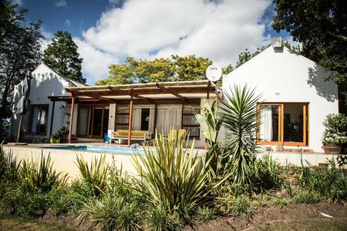 a house with a pool in front of it at Rouana Guest Farm in Stellenbosch