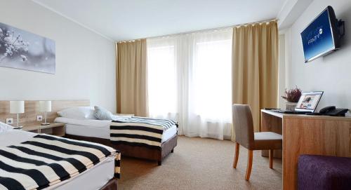 Pokój hotelowy z 2 łóżkami i biurkiem w obiekcie Hotel Port 110 w Iławie