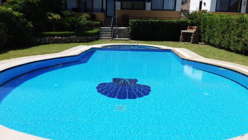 una piscina blu con un ombrellone sopra di Seashell a Líndos