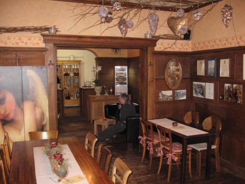 un hombre sentado en una mesa en un restaurante en Weingut Day, en Zell an der Mosel