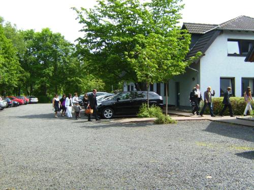 a group of people standing around a car parked in a driveway at Seminarhotel Jakobsberg in Grünberg