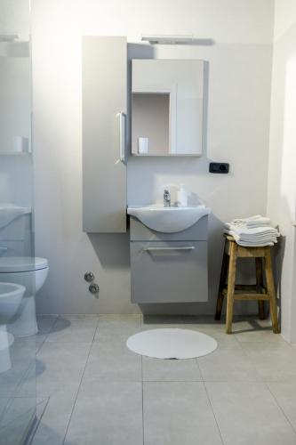 a white bathroom with a sink and a toilet at Boulevard 900 in Revello