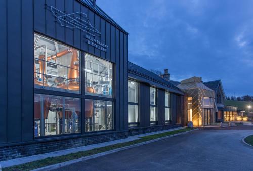 a black building with many windows on a street at Isle of Raasay Distillery in Raasay