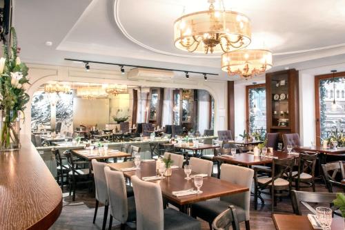 a restaurant with tables and chairs and chandeliers at Pushka INN hotel in Saint Petersburg