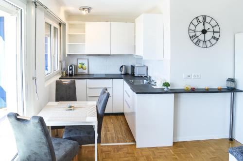 a kitchen with white cabinets and a table with chairs at Studio with Lake View in Montreux