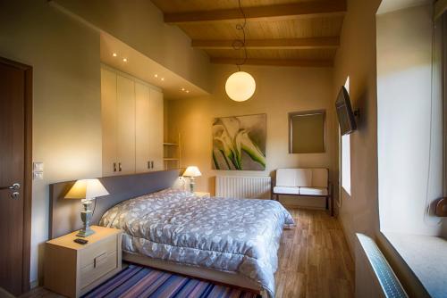 1 dormitorio con 1 cama y 1 mesa con lámpara en Archanes Residences, en Archanes