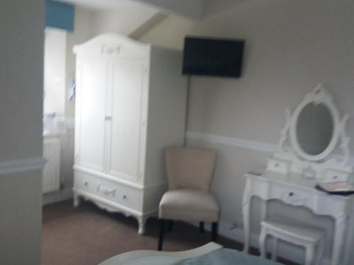a room with a mirror and a chair and a dresser at New Hall Bank in Bowness-on-Windermere