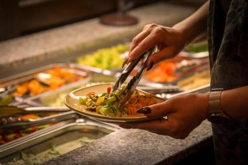 a person holding a plate of food with tongs at Mettner Hof in Metten
