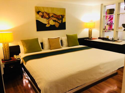 a large white bed in a room with two lamps at Baipho Lifestyle in Patong Beach