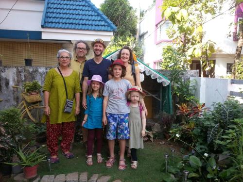 a family posing for a picture in front of a house at El Casa Homestay in Cochin