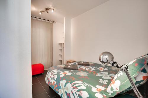 ビアリッツにあるWelkeys Apartment Mazagranのベッドルーム1室(ベッド1台、赤い椅子付)