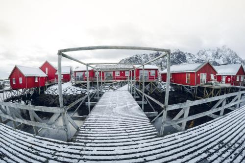 a snow covered bridge with red buildings and houses at Hattvika Lodge in Ballstad