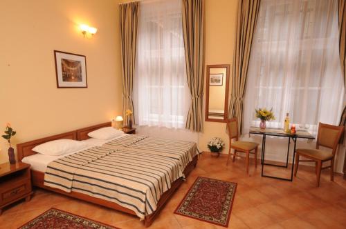 - une chambre avec un lit, une table et une fenêtre dans l'établissement Budapest Museum Central, à Budapest