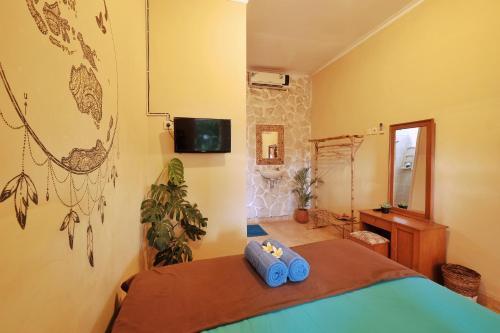 a bedroom with a bed with blue towels on it at Omah Konco Yogyakarta in Yogyakarta