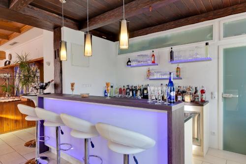 a bar with white stools in a room at Bavaria Hotel Münchner Hof Superior in Stuttgart