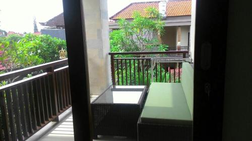 a balcony with a green bench on a building at ThreeWin Homestay in Ubud