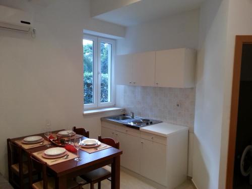 een kleine keuken met een tafel en een wastafel bij Apartments Dalmatino in Dubrovnik
