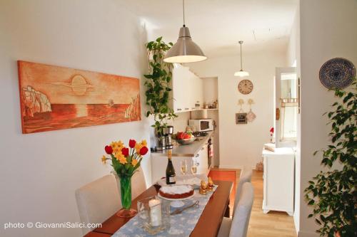 a kitchen and dining room with a table with flowers at Casa Azzurra in Menaggio