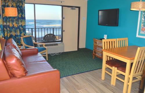 a living room with a couch and a table and a television at Sun Viking Lodge - Daytona Beach in Daytona Beach