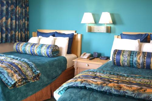 a bedroom with two beds and a blue wall at Sun Viking Lodge - Daytona Beach in Daytona Beach