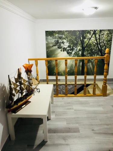 a white bench in front of a balcony with a painting at Casa Rural Setenil in Setenil
