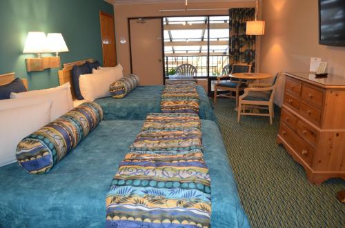 a hotel room with two beds and a dresser at Sun Viking Lodge - Daytona Beach in Daytona Beach