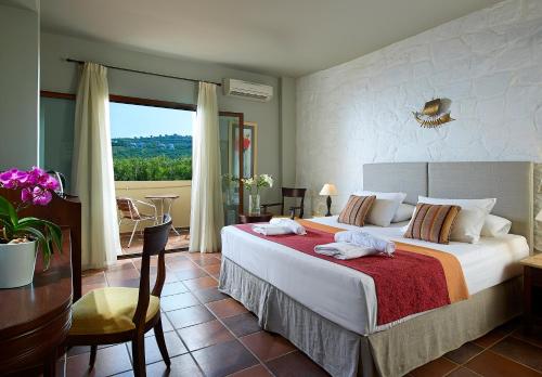 a bedroom with a large bed and a balcony at Mistral Hotel - For Solo Travelers in Maleme