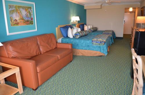 a hotel room with a couch and a bed at Sun Viking Lodge - Daytona Beach in Daytona Beach