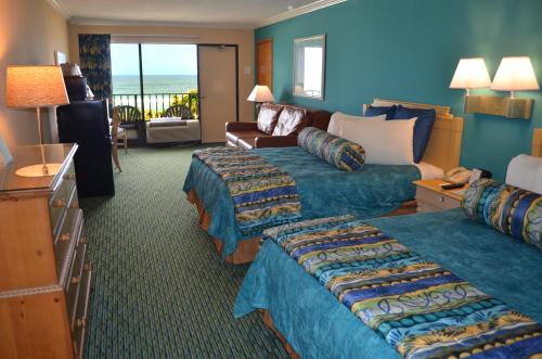 a hotel room with two beds and a living room at Sun Viking Lodge - Daytona Beach in Daytona Beach
