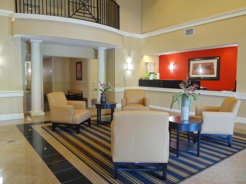 a lobby with a waiting room with chairs and tables at LoneStar Suites in Webster