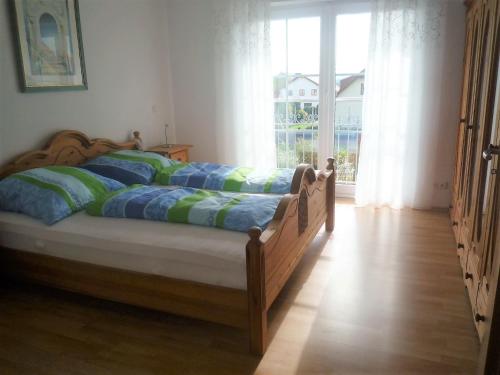 ヴァイトハウスにある"Villa Sabine"の窓付きの客室で、ベッド1台(緑と青の枕付)