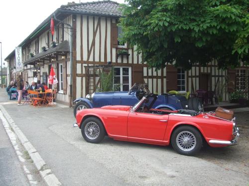 a red car parked on the side of a street at La petite auberge in Châtelraould-Saint-Louvent