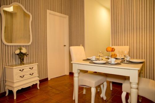 a dining room with a table and chairs and a mirror at Elements Rooms in Toledo