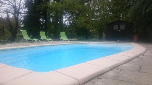 une piscine avec des chaises et une maison dans l'établissement L'écurie, à Saint-Germain-lès-Arlay