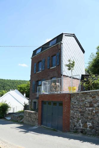 a brick house with a garage in front of it at La petite maison in Aywaille